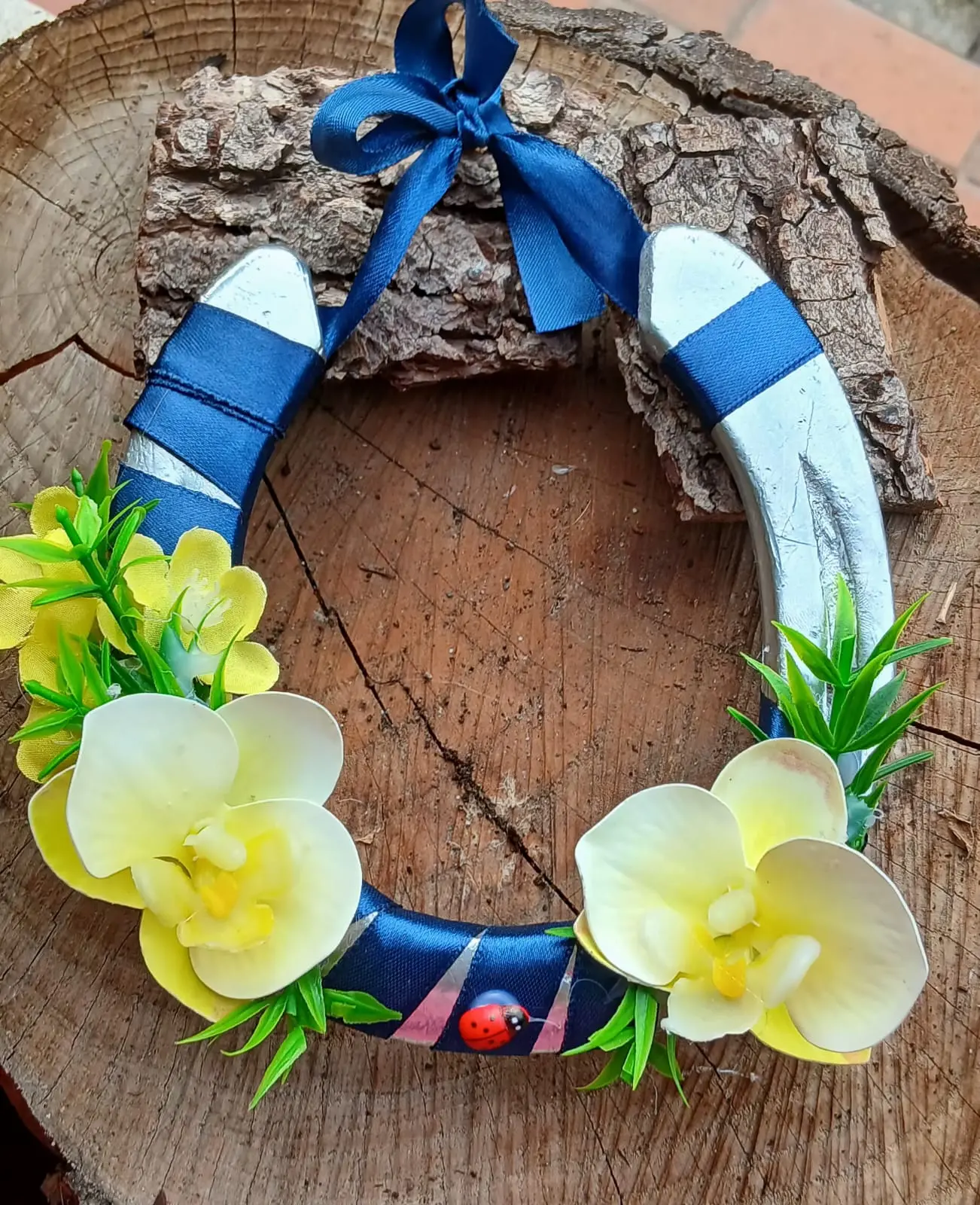 Ferro di cavallo artigianale decorato con nastro blu e orchidee