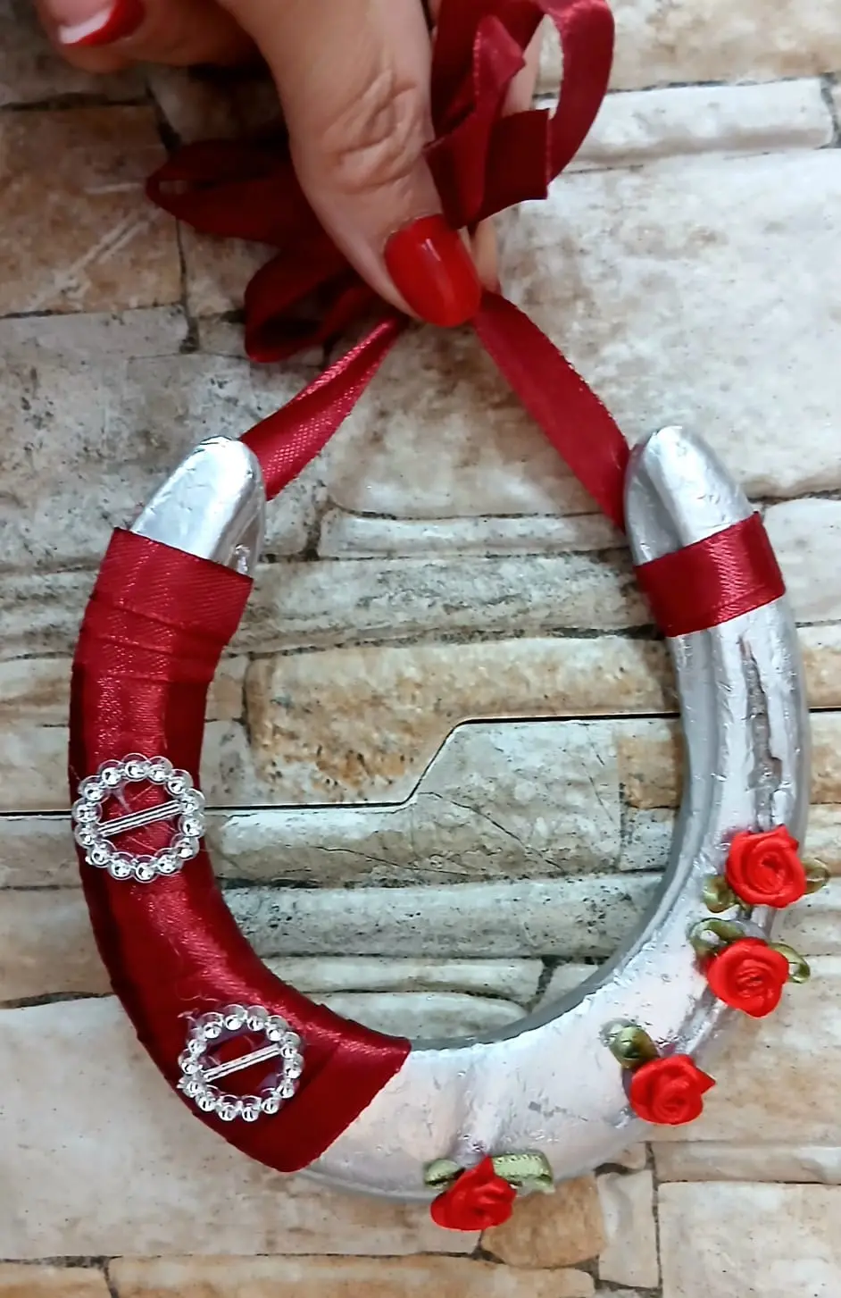 Ferro di cavallo artigianale decorato con nastro rosso e rose